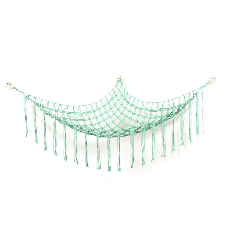 A teal mesh hammock with fringe is shown, designed as a hanging organizer for plush toys.