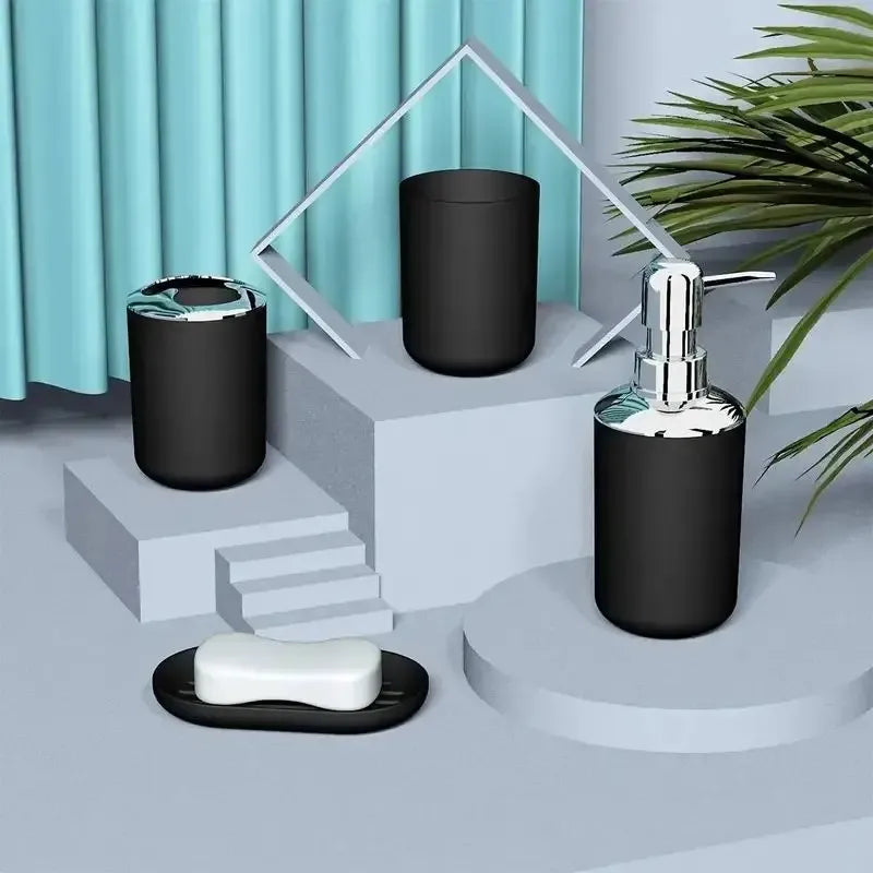 A set of four bathroom accessories including a soap dispenser and holder displayed on a light gray surface.