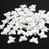 A pile of 100 white acrylic pearl spacer beads shaped like butterflies.