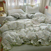 A floral duvet cover set featuring light green and white patterned fabric with matching pillowcases and a flat sheet displaye