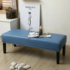 A blue waterproof PU stretch bench cover is placed on a wooden floor next to a white cabinet.