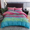 A teal and pink geometric duvet cover set with patterned pillows displayed on a bed.