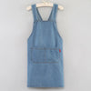 A light blue denim cross-back apron with chest pockets and a small red tag hanging from the pocket.