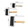 A set of rubber ink rollers for printmaking and stamping, featuring black rollers with light wood handles.