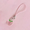 A pink strawberry resin charm attached to a clear elastic cord and silver keyring.