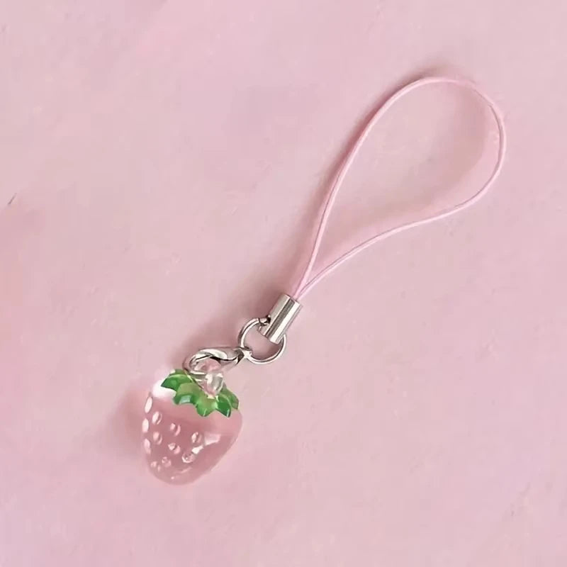 A pink strawberry resin charm attached to a clear elastic cord and silver keyring.