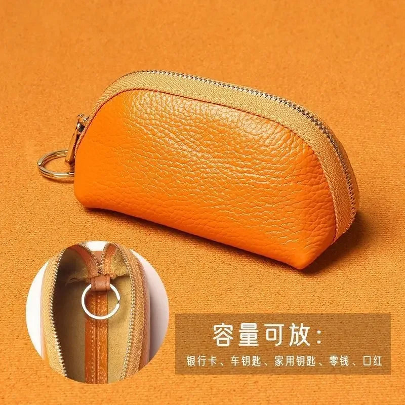 Orange PU leather key organizer wallet with zipper shown against an orange background.