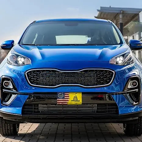 A close-up of a blue car with a Cuban flag metal license plate mounted on the front grille.