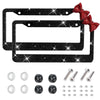 Black rhinestone license plate frame with a red bow accent and various mounting hardware.