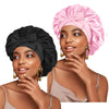 A woman models a pink satin sleeping bonnet with an adjustable tie.