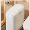 A white touchless trash can with an auto bagging feature is shown in a bathroom setting.