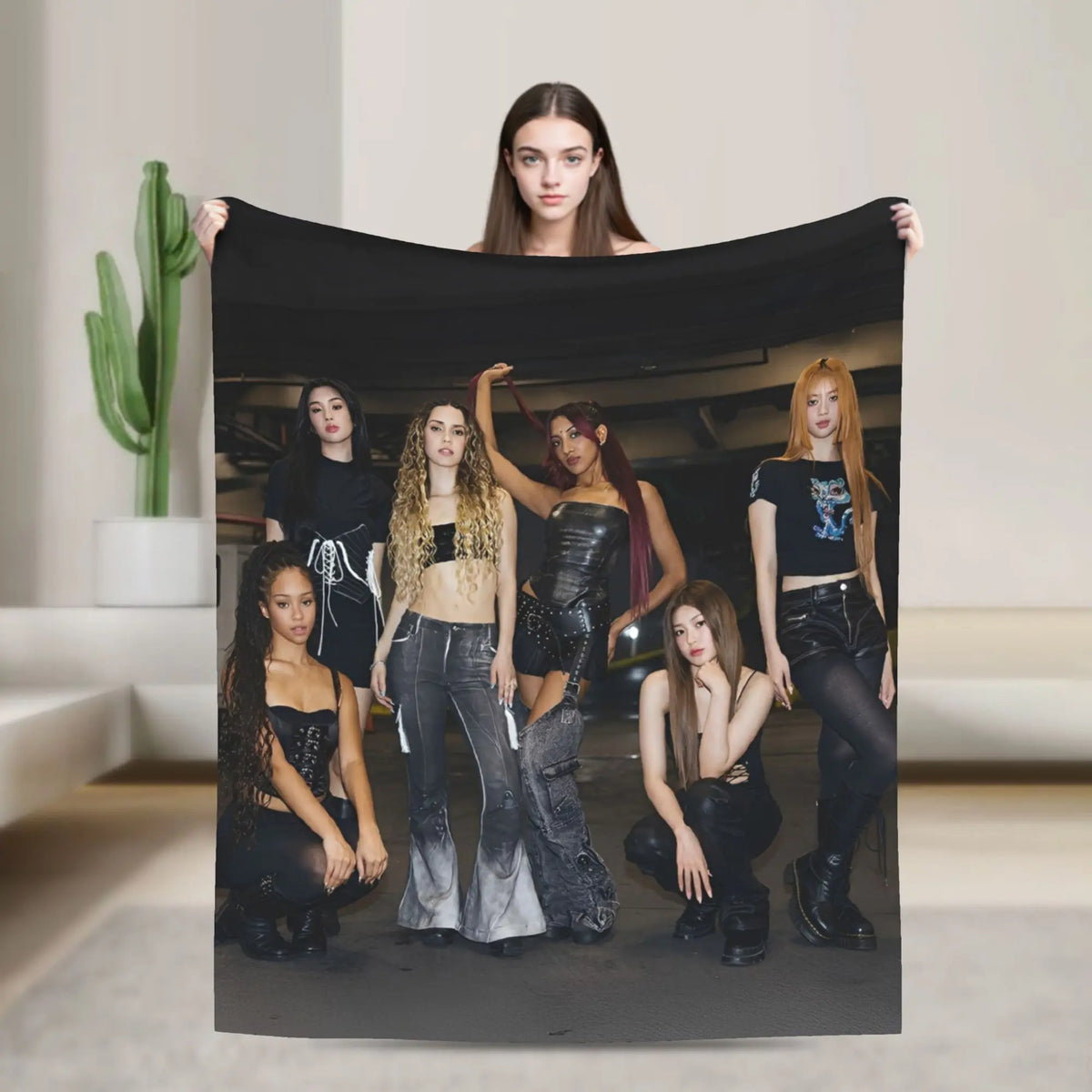 A photo of six young women posing with a black microfiber fleece throw blanket.