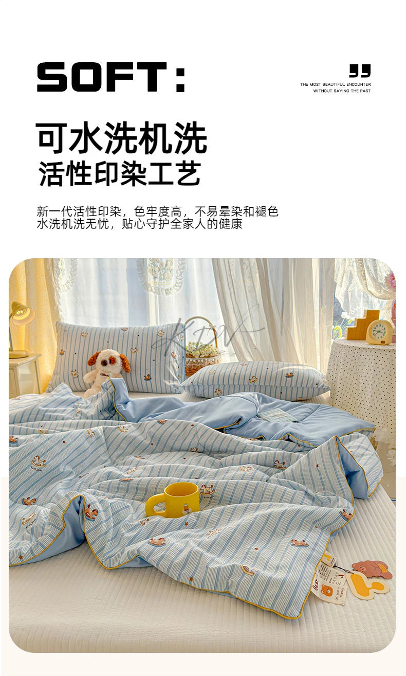 A light blue and white striped quilt featuring playful cartoon prints, displayed on a bed.