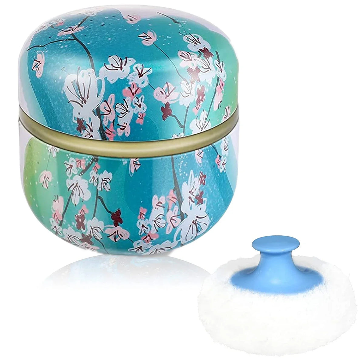 A round, teal and white patterned refillable loose powder container with a white travel puff applicator.