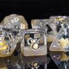 A close-up of a set of clear resin dice featuring adorable animal figures and numbers on a reflective surface.