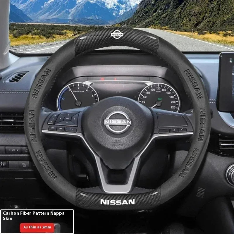 Interior view of a Nissan steering wheel with carbon fiber patterned grips and controls.