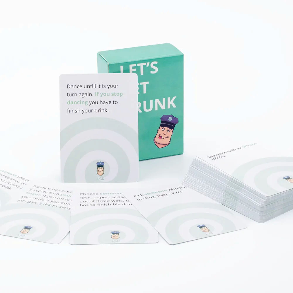 A box of Let's Get Drunk drinking cards and several individual cards are displayed on a white surface.