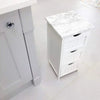 White cabinet with marble top and drawers on a light tile floor.
