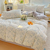 A floral duvet cover set featuring light blue and white patterns on a bed with matching pillows.