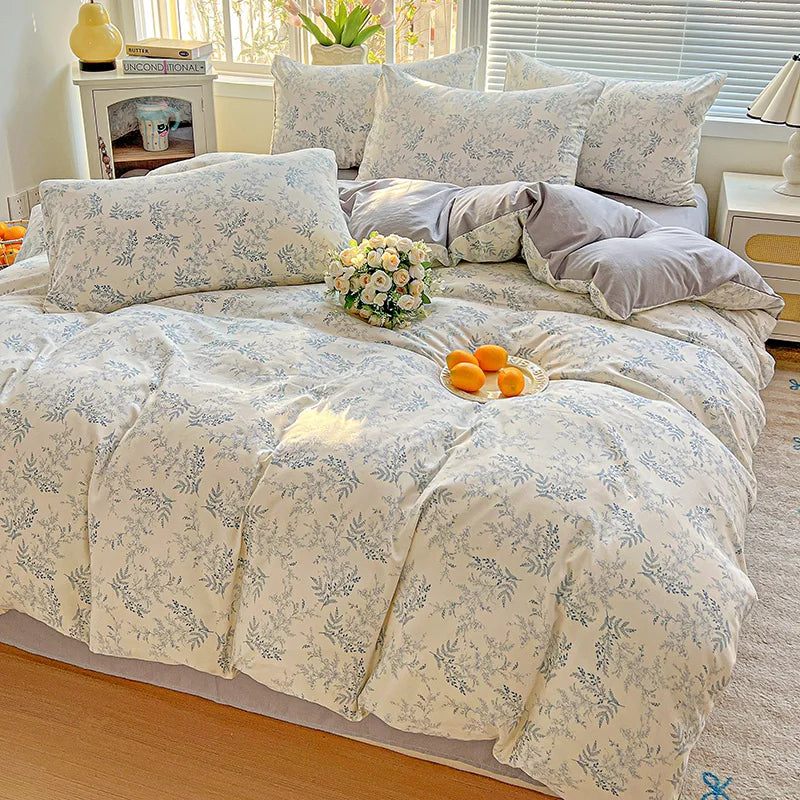 A floral duvet cover set featuring light blue and white patterns on a bed with matching pillows.