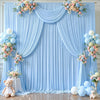 Helles blaues Stoff-Hintergrundvorhang mit Blumenarrangements und Ballons für eine Feier.