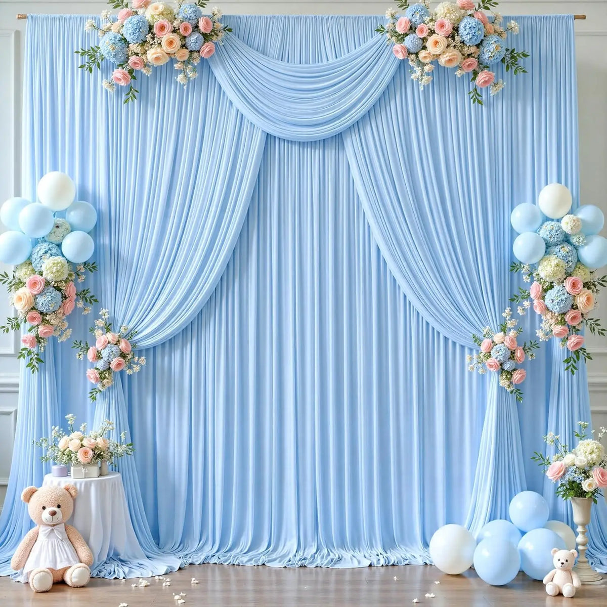 Helles blaues Stoff-Hintergrundvorhang mit Blumenarrangements und Ballons für eine Feier.
