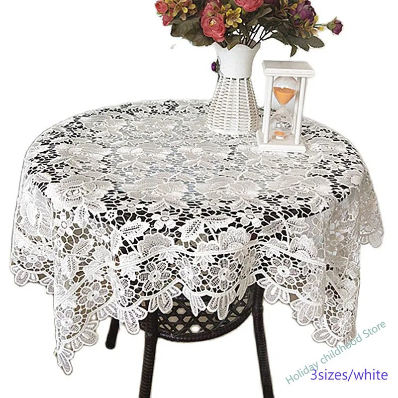White lace tablecloth with an embroidered rose design set on a table.