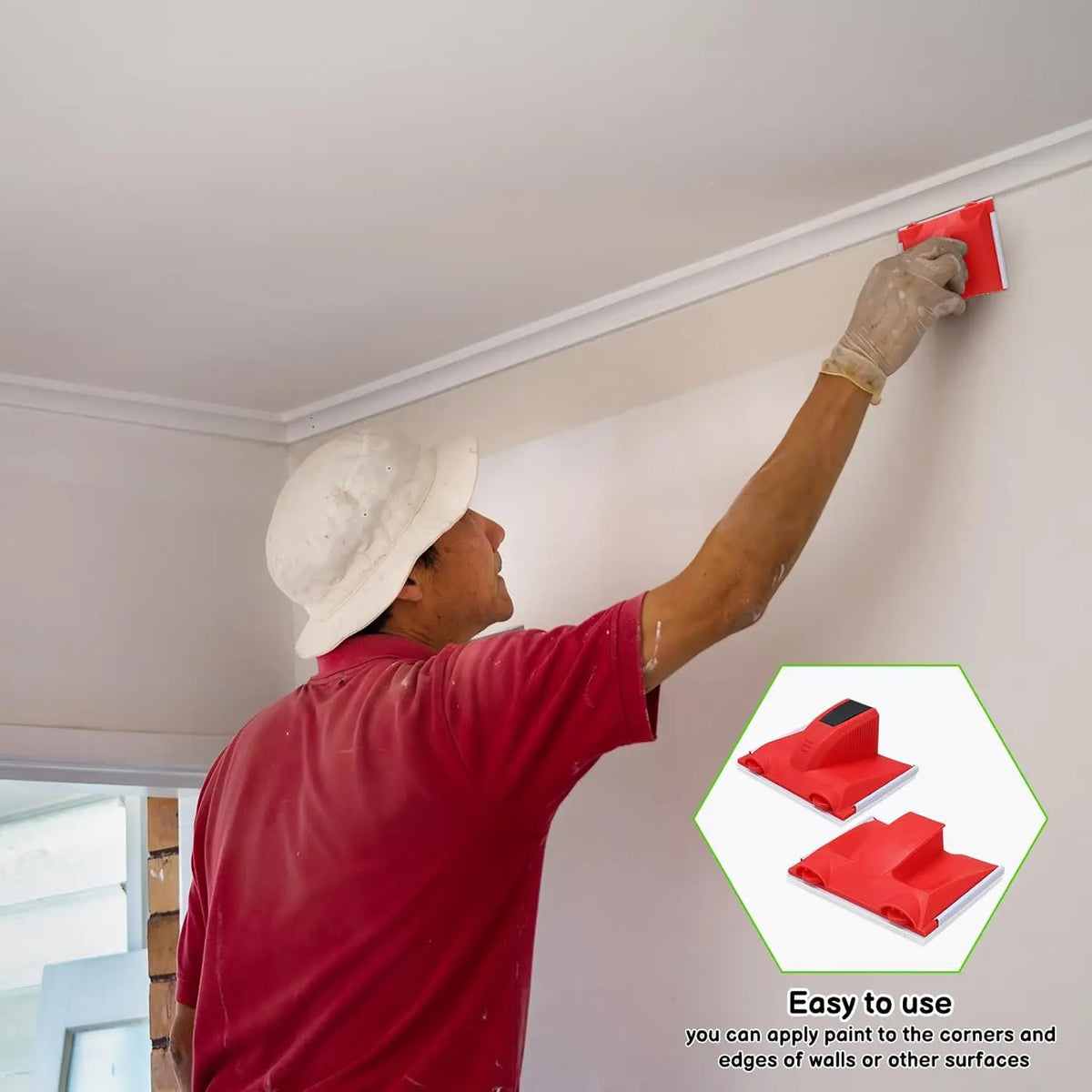 A person is using a red paint edger tool to apply paint to the corners and edges of a white wall.