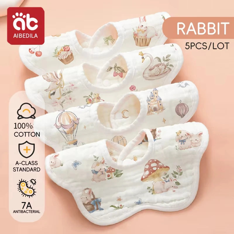 A set of five white soft cotton muslin bandana bibs for babies with floral and animal prints