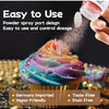 A hand is spraying edible gold dust or glitter powder onto a colorful cupcake for decoration.