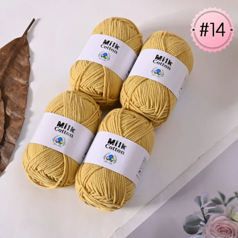 Five skeins of yellow Milk Cotton yarn are displayed on a white surface, ready for knitting or crochet projects.