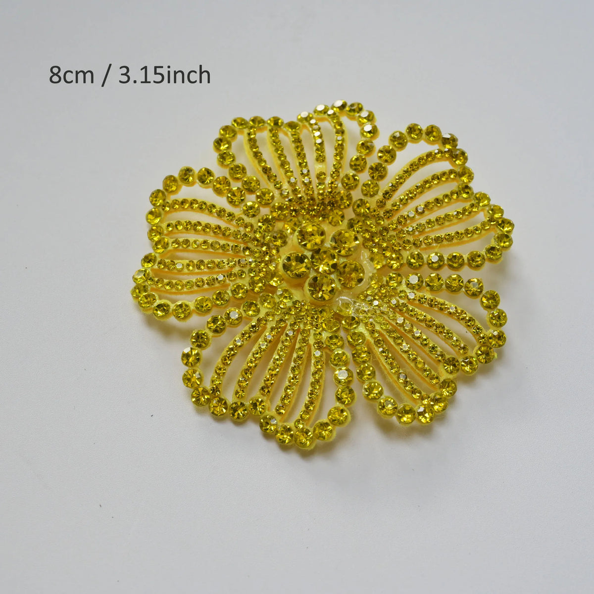 A bright yellow crystal rhinestone flower patch with a textured, petal-like design.