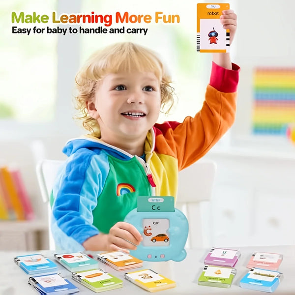 A smiling toddler holds up a robot learning toy and various flashcards for kids.