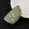 A light green durable TPU car key fob cover resting on a white plate.