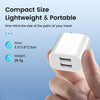 A hand holds a white compact dual-port USB wall charger, highlighting its small size and portability.