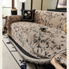 Beige bestickter Chenille-Sofasbezug, drapiert über ein helles Sofa mit dunklen Akzenten.
