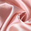 Pink satin fabric draped in soft folds showing luxurious texture for events