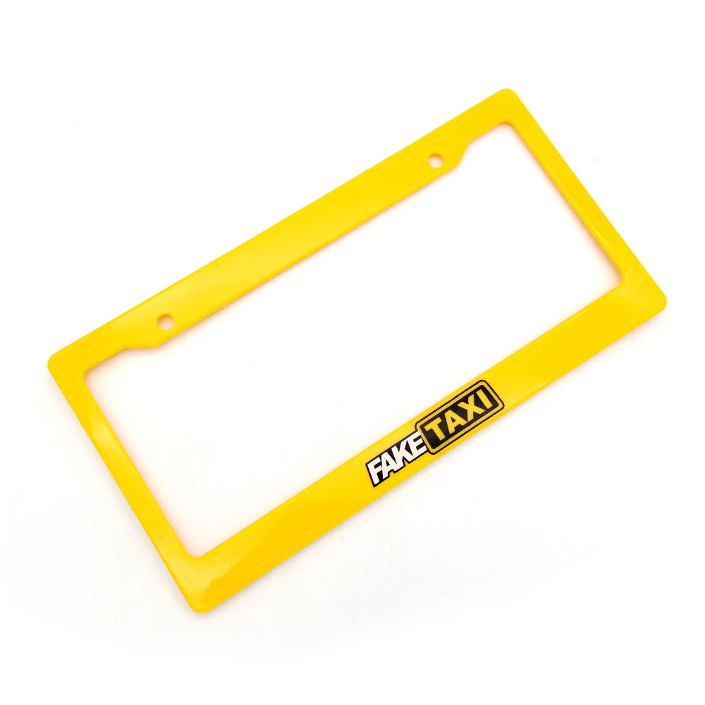 A yellow racing style license plate frame with the text FAKE TAXI