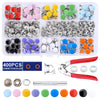 A collection of metal snap fasteners, various colors, and a pair of pliers tool.