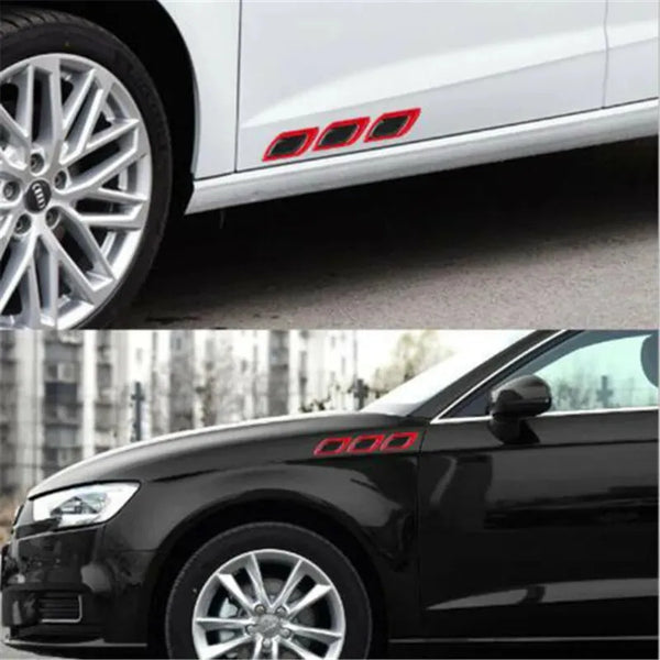 Close-up of a white car showing red reflective safety strips on the side and a black car with similar strips.