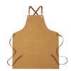 A tan professional chef apron with cross-back straps and multiple tool pockets.