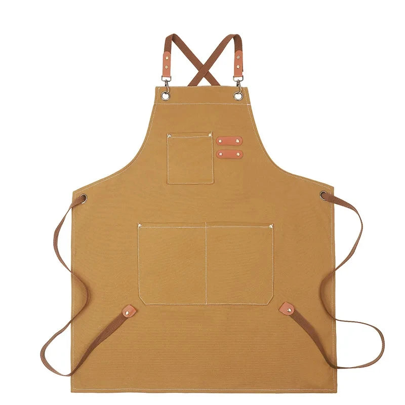 A tan professional chef apron with cross-back straps and multiple tool pockets.