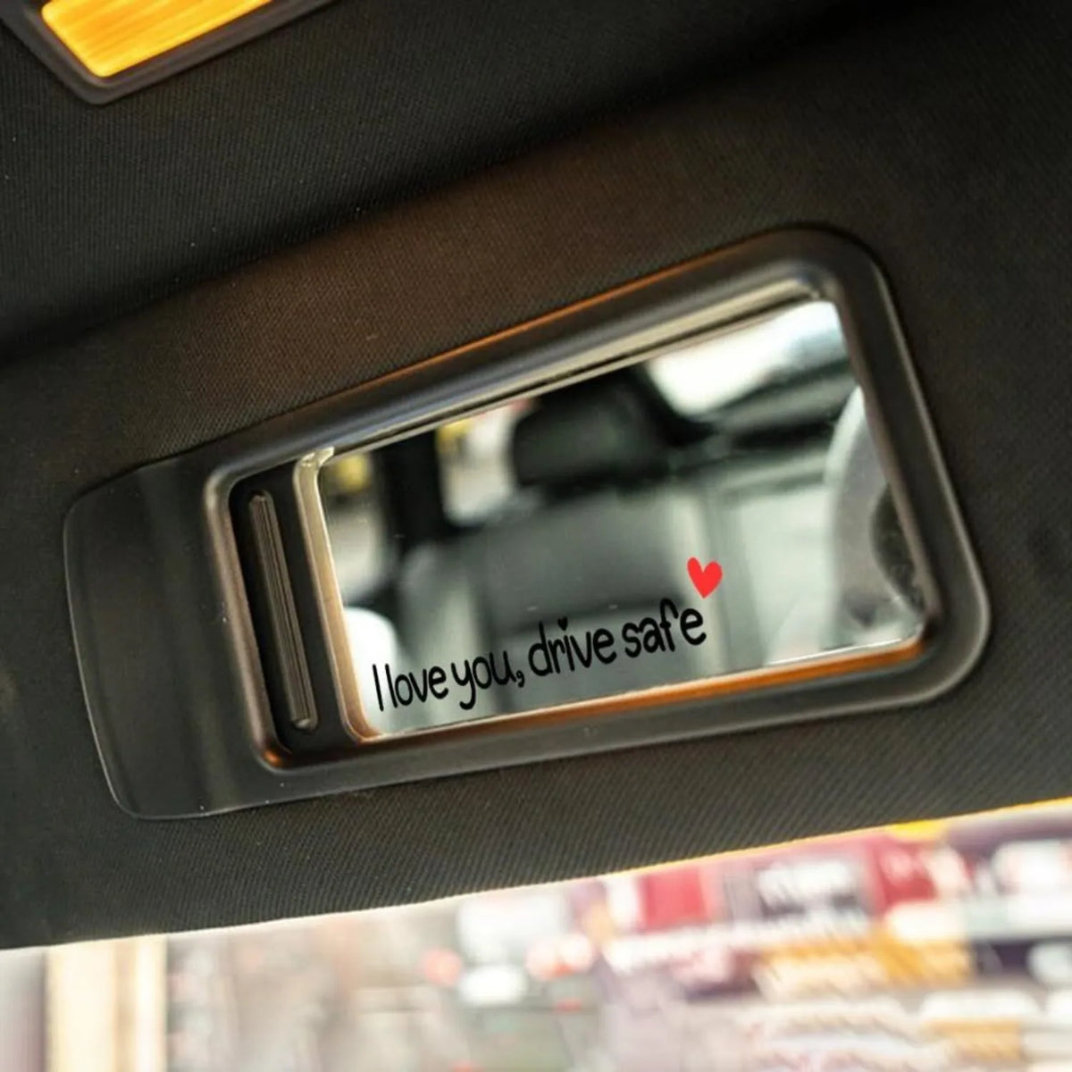 A clear plastic decal sticker set with the text I love you drive safe is mounted on a dark car interior panel.