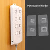 A white patch panel holder and three transparent adhesive wall hooks are shown against a wooden background.