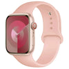 A pink silicone sport band worn around an Apple Watch.