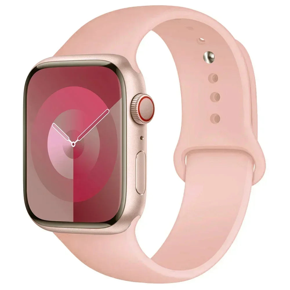 A pink silicone sport band worn around an Apple Watch.