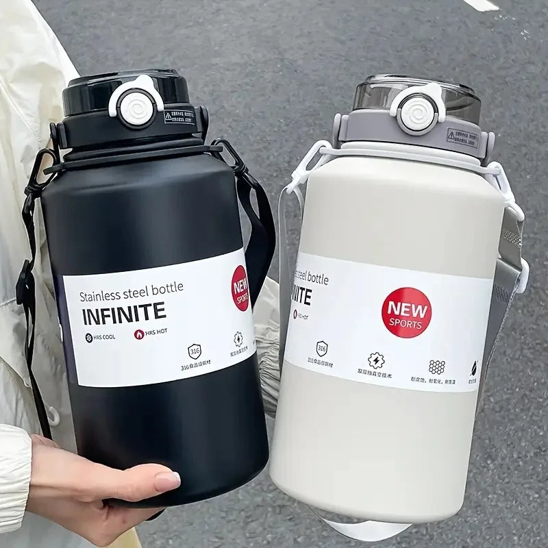 A black 2L insulated stainless steel tumbler with a lid and straw is held by a person.