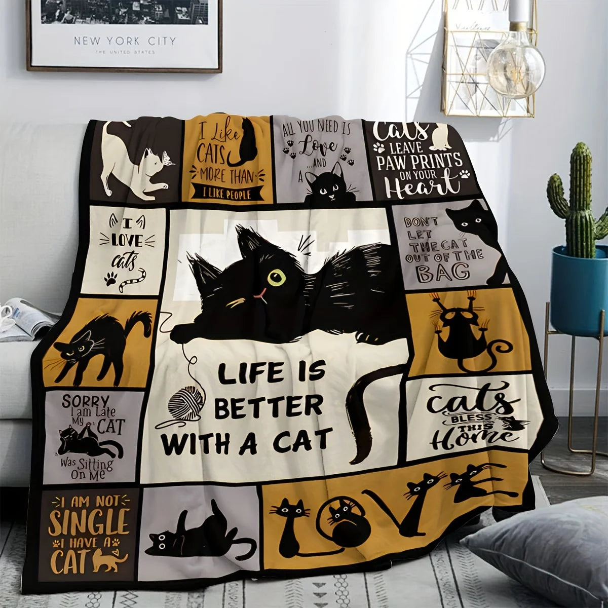 A black and gold patterned flannel throw blanket featuring various cat illustrations for bed or sofa.