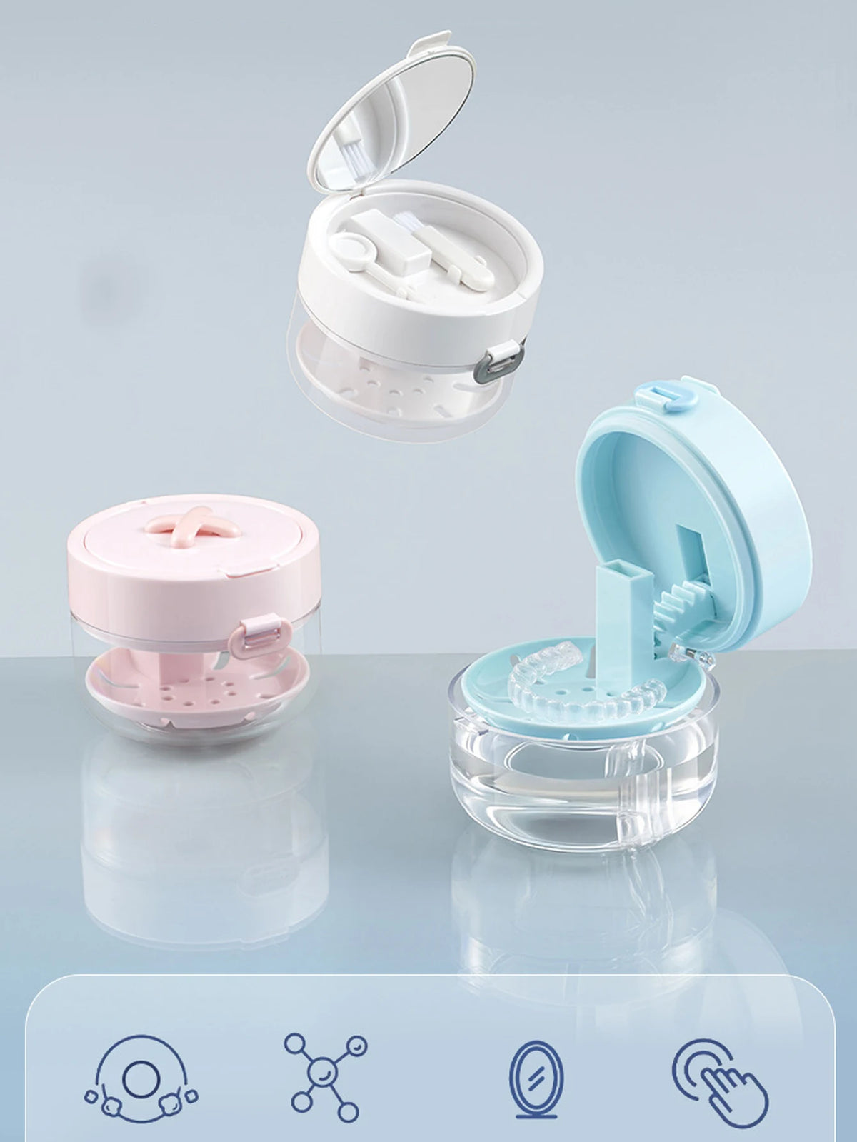 A portable denture case with a lid and cleaning brush storage is shown in pink and light blue colors.