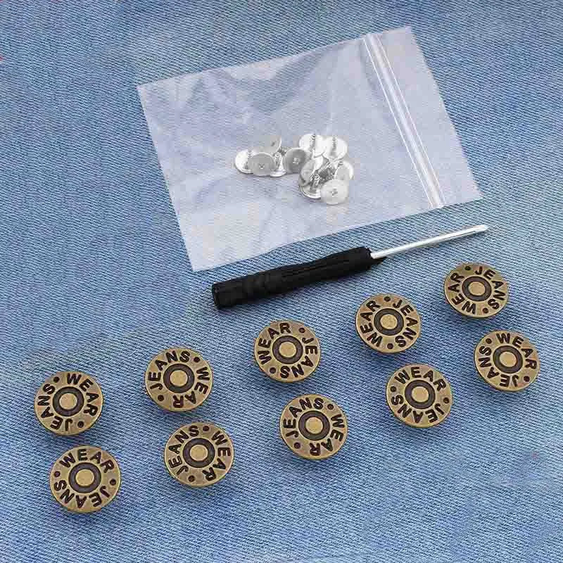 A small silver snap button kit is displayed on a translucent plastic bag against a blue denim background.